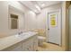 Classic bathroom with a single sink vanity, tile floor, and a doorway with stained glass at 12 Lake Link Dr, Winter Haven, FL 33884