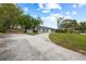 Attractive home featuring a lush lawn, mature trees, and a paved driveway at 12 Lake Link Dr, Winter Haven, FL 33884