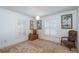 Bright bedroom with neutral carpet, tropical-themed art, and windows with white shutter blinds at 12172 Se 96Th Ter, Belleview, FL 34420