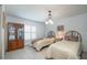 Cozy bedroom featuring twin beds, natural light from a large window, and a vintage display cabinet at 12172 Se 96Th Ter, Belleview, FL 34420