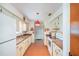 Efficient kitchen layout with ample counter space, white appliances, tile floors, and a vintage hanging light at 12172 Se 96Th Ter, Belleview, FL 34420