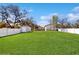 Spacious backyard with healthy green grass, a shed for storage, and a white fence at 3230 Baird Ave, Lakeland, FL 33805