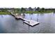 Scenic view of the wooden community dock extending into the lake with lush green surroundings at 6244 Great Bear Dr, Lakeland, FL 33805