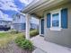 Inviting covered front porch with a stylish blue door and matching shutters on a well-maintained home at 6244 Great Bear Dr, Lakeland, FL 33805