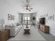 Bright living room featuring a ceiling fan, tile floors, neutral paint, and an abundance of natural light at 6244 Great Bear Dr, Lakeland, FL 33805