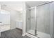 Modern bathroom featuring a glass-enclosed shower with tiled walls and gray wood-look flooring at 3739 Bergamot St, Lake Alfred, FL 33850