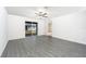 Spacious bedroom with modern gray wood-look flooring, ceiling fan, and sliding glass doors to the backyard at 3739 Bergamot St, Lake Alfred, FL 33850