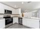 Modern kitchen featuring white cabinets, stainless steel appliances, and granite countertops with seating at the peninsula at 3804 Corsican Pl, Lake Alfred, FL 33850