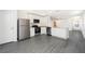 Modern open-concept kitchen with white cabinets, stainless steel appliances and granite countertops, flowing into the living area at 3804 Corsican Pl, Lake Alfred, FL 33850