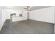Spacious living room with gray wood-look floors, a ceiling fan, and an open concept design perfect for entertaining at 3804 Corsican Pl, Lake Alfred, FL 33850
