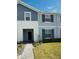 Inviting two-story townhome featuring a mix of siding, manicured lawn, and walkway leading to the front door at 627 Jasmine Ln, Davenport, FL 33897