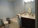 This bathroom offers blue walls, a vanity with a dark wood cabinet, a toilet, and a tub at 1547 Belfast Ct, Apopka, FL 32712