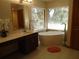 Bathroom featuring double sinks, a soaking tub, and natural light from a large window at 1547 Belfast Ct, Apopka, FL 32712