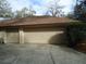 Attached two-car garage with neutral paint and concrete driveway on a sunny day at 1547 Belfast Ct, Apopka, FL 32712