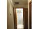 This hallway offers an entrance to a white shower, a white door, and wood-trimmed doorways at 1547 Belfast Ct, Apopka, FL 32712