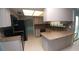 Well-lit kitchen features black appliances, tiled backsplash, and island with counterspace at 2502 Vine St, Orlando, FL 32806