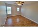 Bedroom featuring hardwood floors, a ceiling fan and two windows for natural light at 6187 Brookhill Cir, Orlando, FL 32810