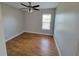 Bedroom featuring hardwood floors, a ceiling fan and a window for natural light at 6187 Brookhill Cir, Orlando, FL 32810