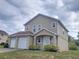 Charming two-story home with a well-maintained lawn and two-car garage provides ample parking and curb appeal at 6187 Brookhill Cir, Orlando, FL 32810