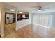 Spacious living room adjacent to an open kitchen with tile flooring and a sliding glass door at 6187 Brookhill Cir, Orlando, FL 32810