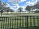Backyard featuring a grass lawn, black metal fence, and a serene lake view at 2188 Palm Tree Dr, Kissimmee, FL 34759