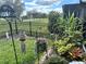 Backyard featuring a view of lake, flowers, lush vegetation and black metal fence at 2188 Palm Tree Dr, Kissimmee, FL 34759