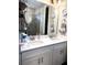 Bright bathroom featuring a double sink vanity, large mirror, and a glass-enclosed shower at 2188 Palm Tree Dr, Kissimmee, FL 34759
