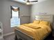 Bright bedroom featuring a ceiling fan, large window, and a comfortable queen-sized bed with yellow bedding at 2188 Palm Tree Dr, Kissimmee, FL 34759