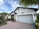 Charming home featuring a well-maintained garage, brick driveway, and screen front porch at 2188 Palm Tree Dr, Kissimmee, FL 34759