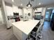 Bright kitchen features white cabinets, stainless steel appliances, and a large island with counter seating at 2188 Palm Tree Dr, Kissimmee, FL 34759