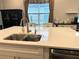 Kitchen island with sink and faucet, with modern white cabinetry and hardware at 2188 Palm Tree Dr, Kissimmee, FL 34759