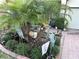 Close up of an ornate garden with lush foliage and decorative heron sculptures lining the brick driveway at 2188 Palm Tree Dr, Kissimmee, FL 34759