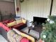 Cozy screened patio with red sectional sofa, throw pillows, and a flat screen TV at 2188 Palm Tree Dr, Kissimmee, FL 34759