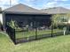 Enclosed patio with black metal fencing and lush landscaping create a private backyard retreat at 2188 Palm Tree Dr, Kissimmee, FL 34759
