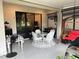 Covered porch with outdoor dining table, chairs, and a comfortable swing at 2188 Palm Tree Dr, Kissimmee, FL 34759