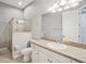 Bathroom with a shower behind glass door, toilet, sink with a mirror at 6327 Ashley Dr, Lakeland, FL 33813