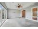 Spacious bedroom with neutral walls and carpet with large glass sliding doors and a ceiling fan at 6327 Ashley Dr, Lakeland, FL 33813