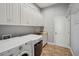 Well-equipped laundry room with white cabinetry, washer, dryer, and sink area at 6327 Ashley Dr, Lakeland, FL 33813