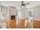 Cozy living room featuring hardwood floors, a ceiling fan, fireplace, and lots of natural light at 6327 Ashley Dr, Lakeland, FL 33813