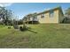 Back of house features sliding glass door and deck with spacious grassy backyard and mature trees at 6327 Ashley Dr, Lakeland, FL 33813