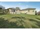 Rear view of house featuring screened patio, second building, and sprawling green backyard at 6327 Ashley Dr, Lakeland, FL 33813