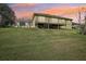 Back of home featuring large rear patio and expansive grass yard at sunset at 6327 Ashley Dr, Lakeland, FL 33813