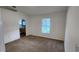 Cozy bedroom with soft carpeting, bright window, and an archway leading to the en-suite bathroom at 1404 Country Chase Dr, Lakeland, FL 33810