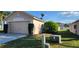 Side view of a one-story home featuring an attached two-car garage, manicured lawn, and minimal landscaping at 1404 Country Chase Dr, Lakeland, FL 33810