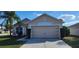 Home with a large two-car garage, neutral paint, and well-kept landscaping at 1404 Country Chase Dr, Lakeland, FL 33810