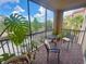 Enjoy outdoor living on this screened patio with chairs, table, and green plants at 8010 Tuscany Way # 5301, Davenport, FL 33896