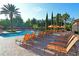 Relaxing pool with rows of lounge chairs under umbrellas and sunny skies at 8010 Tuscany Way # 5301, Davenport, FL 33896