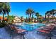 Beautiful community pool with palm trees and lounge chairs under a clear sky at 8010 Tuscany Way # 5301, Davenport, FL 33896