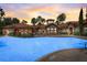 Community pool at dusk features a large pool, clubhouse, and palm tree landscaping at 8010 Tuscany Way # 5301, Davenport, FL 33896