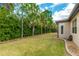 Spacious backyard with manicured lawn and privacy provided by mature trees at 9761 Sw 74Th Pl, Ocala, FL 34481